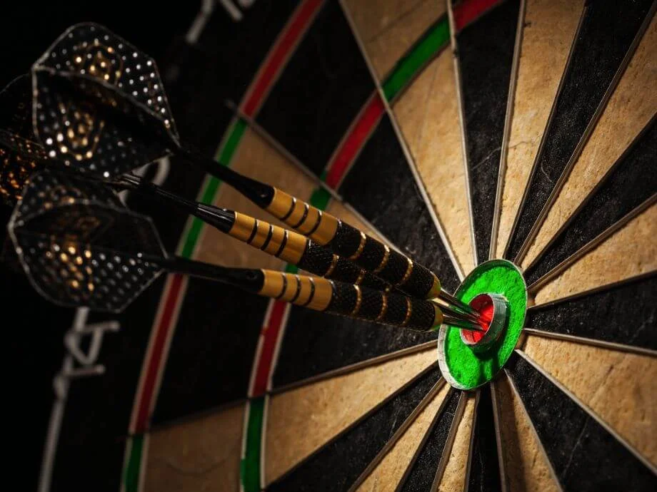 Bullseye! Three darts in the middle of the dartboard.